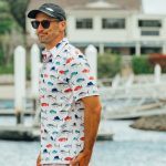 Side view of man wearing Bluewater custom fishing shirt with gamefish pattern near marina