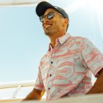 Low angle view of man wearing Tommy gamefishing button-up shirt with marlin dolphin fish and wahoo pattern